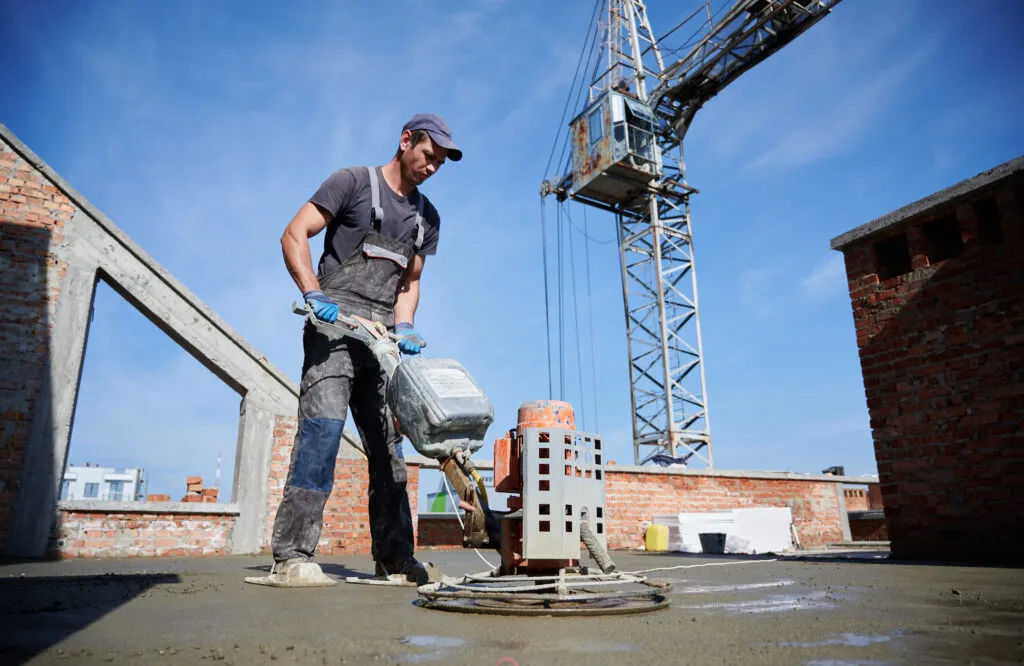 Pracownik wyrównujący płytę fundamentową