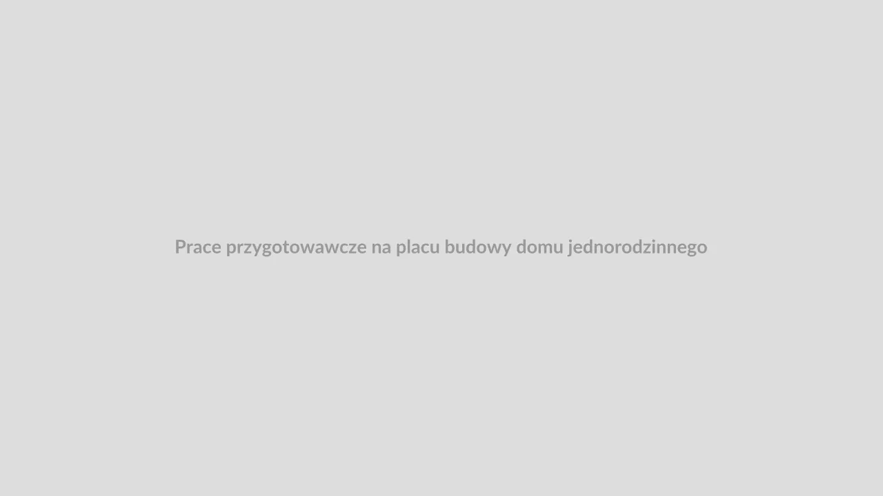Operator żółtej koparki gąsienicowej zdejmujący warstwę humusu na zielonej działce budowlanej pod Bielskiem